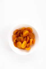 Delicious dried apricots in a bowl on white