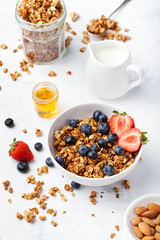 Healthy breakfast Fresh granola, muesli in bowl with milk and berries