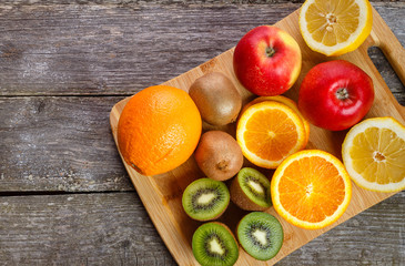 Fresh fruits oranges, kiwi, lemons, apples arranged in a group, natural still life for healthy food. Top view. Empty space for text.