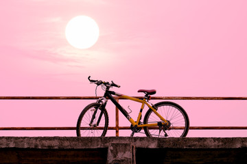 Naklejka premium Beautiful mountain bike on concrete bridge with colorful sunlight ; vintage filter style for greeting card and post card.