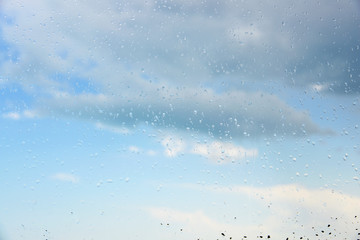 Raindrops on a window.Through the glass sky and clouds