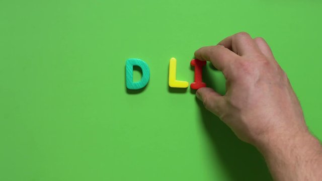 man lays out  inscription "RED LIST"  from colored letters