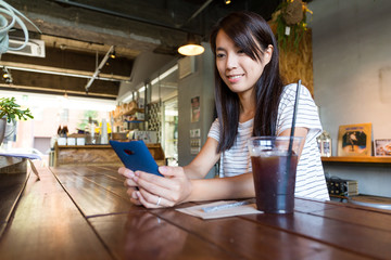 Woman using cellphone in coffee shop