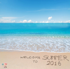 Fototapeta na wymiar welcome to summer 2016 written on a tropical beach
