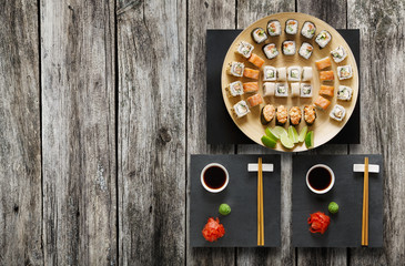 Set of sushi maki and rolls at rustic wood.