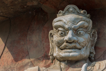 Divinity stone head. Head sculpture in an asian style. The statue of the god of stone face close-up