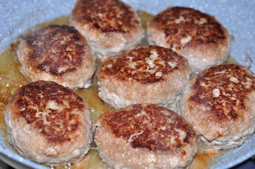 raw burgers, beef in a frying pan