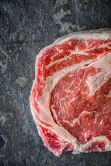 Piece of Ribeye steak on a marble gray-blue slate