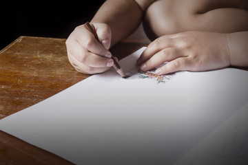 Child or kid hands painting by colour pencil in dark , homework and kid in dim light, kid in countryside, no electricity and kid lifestyle