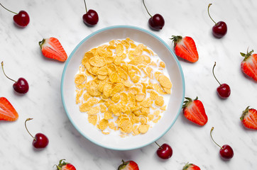 Corn flakes with milk and berries pattern on a marble © papricahome1