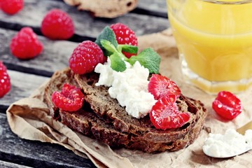 Healthy breakfast with wholegrain bread,cottage cheese and fresh raspberries.Selective focus