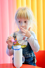 Cute pretty little girl enjoying a milkshake