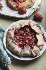 Rustic home made galettes, pastries with strawberries over green