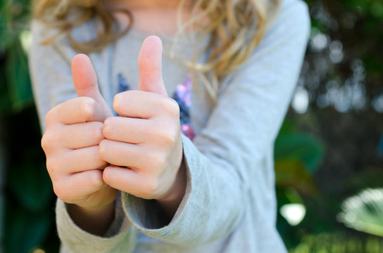 Close up of child giving two thumbs up