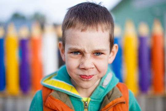 sad kid holds back tears. boy on the playground trying not to cry from the pain or resentment