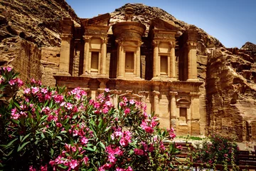 Zelfklevend Fotobehang The oleander shrubs and Monastery Ad-Deir, ancient Nabataean city Petra, Jordan. © sola_sola