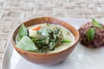 Homemade Green Thai Curry served with brown rice in a bowl and a plate. Originally made in Thailand.