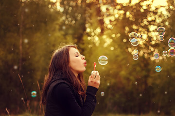 Young girl blowing soap bubbles.