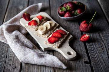 Fruity toast on wooden background. Strawberries, bread, butter and cheese.Vintage style