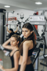 Fototapeta premium Portrait of two sporty girls taking a drink