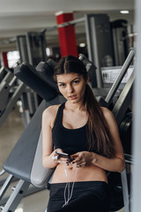 Fototapeta na wymiar Beautiful girl with a phone in the gym