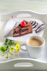 Cup of coffee and chocolate cake with cherries