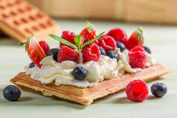 Closeup of waffle with whipped cream and berry fruits - obrazy, fototapety, plakaty