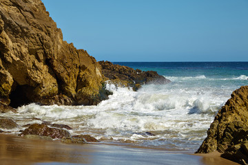 Fototapeta na wymiar Waves beating against coastal rocks on the cliffs