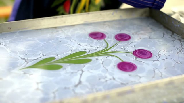 Marbling art process, a woman painting marbling.