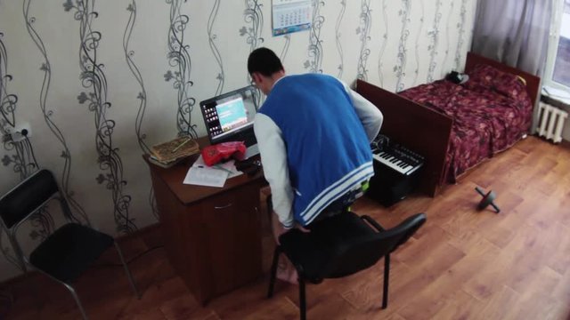 Young boy in dormitory room. Sit at notebook, juggle bottle, eat cookie, study, jump on bed. Student. Bore. Timeapse