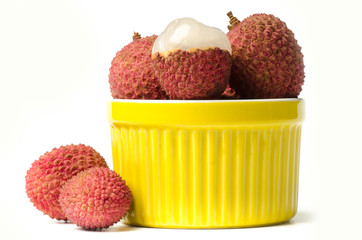 Lychee or litchi (tropical fruit) in yellow bowl on white background