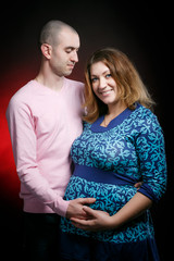 Portrait of a man and his pregnant wife in a studio