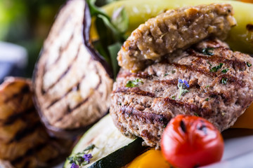 Burgers. Grill burgers. Minced burgers. Roasted burgers with grilled vegetable and herb decoration. Minced meat grilled in a hotel or restaurant.