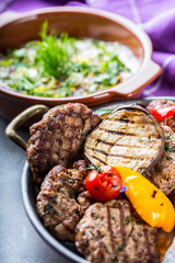 Burgers. Grill burgers. Minced burgers. Roasted burgers with grilled vegetable and herb decoration. Minced meat grilled in a hotel or restaurant.