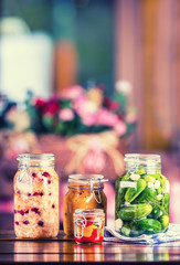 Fototapeta na wymiar Preserving. Pickles jars. Jars with pickles, pumpkin dip, white cabbage, roasted red yellow pepper. Pickled Vegetables. Vegetable being prepared for preserving. Toned image.