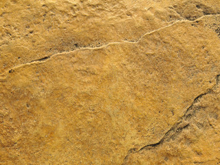 Texture of old rustic wall covered with yellow stucco