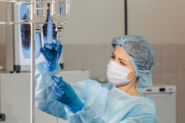 Female doctor adjusting infusion bottle in hospital