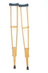 Wooden crutches rest on white wall