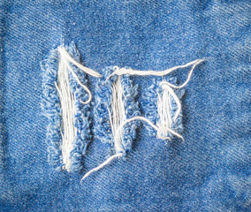 Blue jeans torn denim texture background.