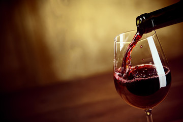 Rotwein in ein Weinglas gießen