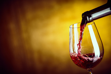 Serving a glass of red wine from a bottle - obrazy, fototapety, plakaty