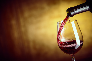 Gießen Sie ein einzelnes Glas Rotwein aus einer Flasche