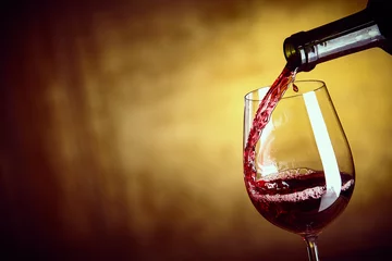 Foto op Aluminium Wijn Een enkel glas rode wijn uit een fles schenken