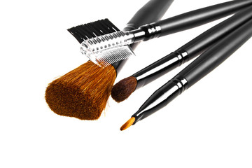 Fototapeta premium Bunch of make-up brushes lying randomly on white background