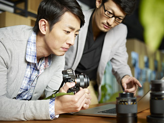 two asian photographers working in studio