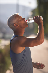 senior jogging man drinking fresh water from bottle