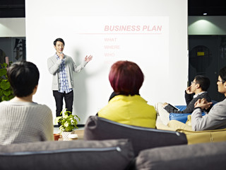 young asian man presenting business plan in front of investors