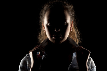 portrait of a girl with the face in shadow on a dark background