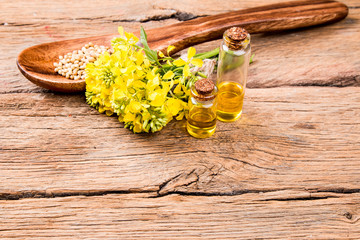 Rape oil and flower on wooden table 