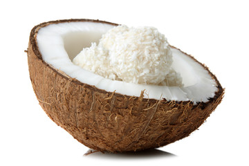half coconut with coconut candies on white isolated background